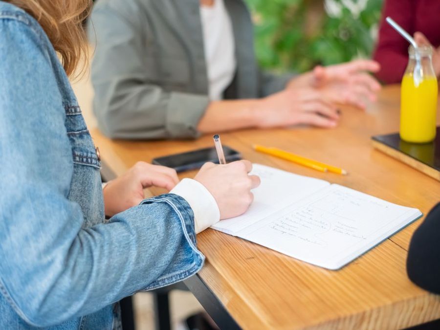 A support coordinator and a participant going through a plan together at a café table